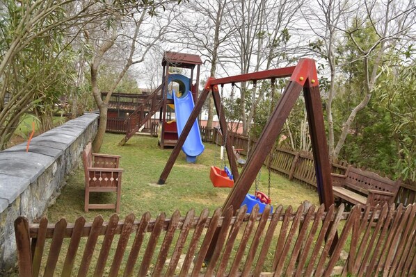 A playground with a swing set, slide, and play structures. - Fener Motel (Sile)