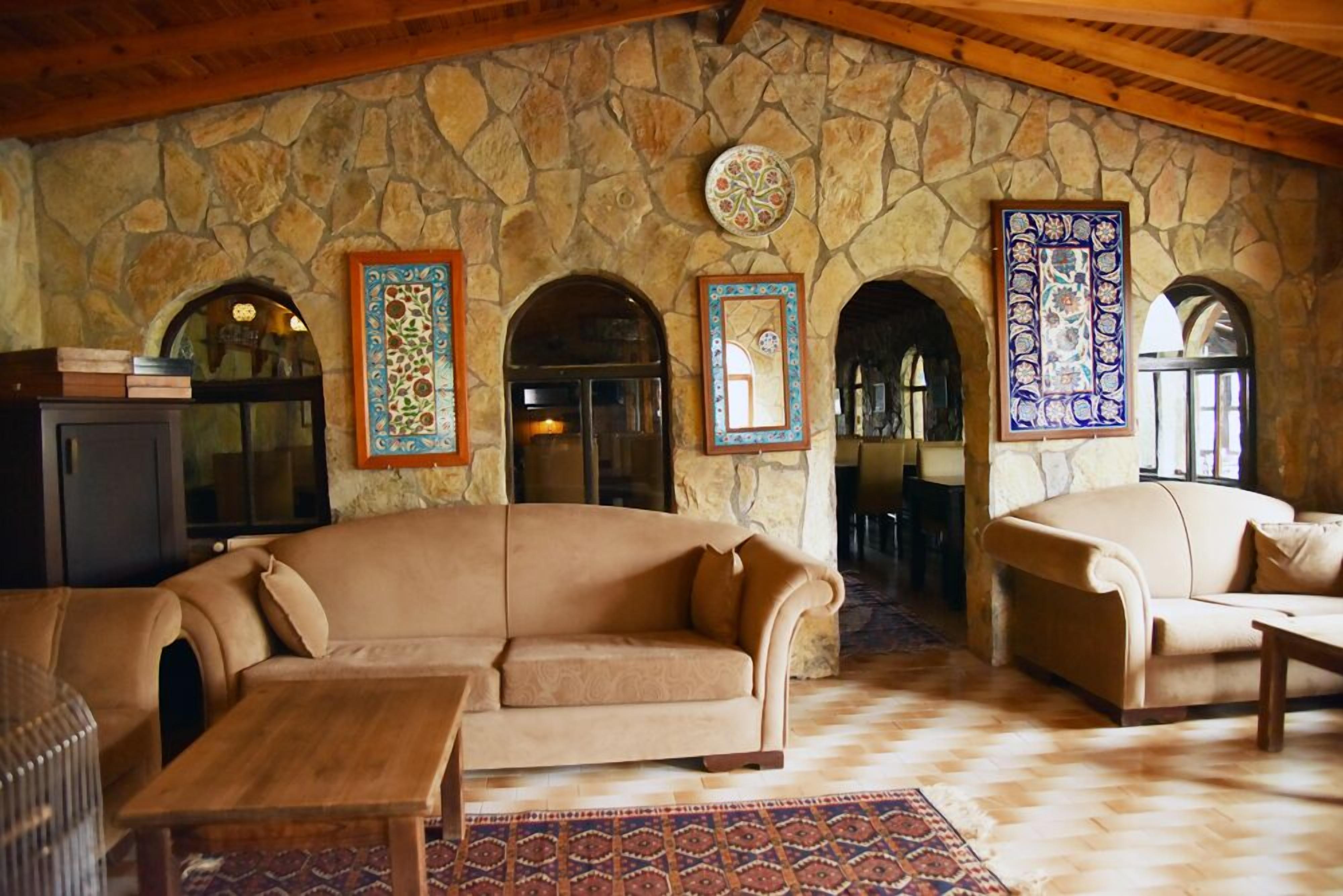 A cozy living room with a stone wall, two sofas, a coffee table, and a fireplace.