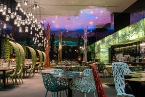 A restaurant with multiple tables and chairs, decorative hanging lights, and a ceiling with a light display. - arTree hotel (Taipei)