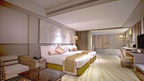 A modern hotel room with a large bed, a sitting area with a glass coffee table, and a separate desk with a chair. - arTree hotel (Taipei)