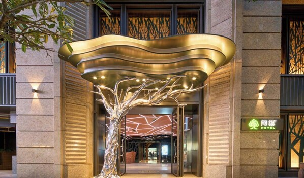 A hotel entrance with a modern design, including a tree-like structure and a sign indicating the hotel name. - arTree hotel (Taipei)