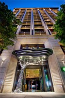 Un edificio moderno con una entrada destacada que presenta una escultura única.