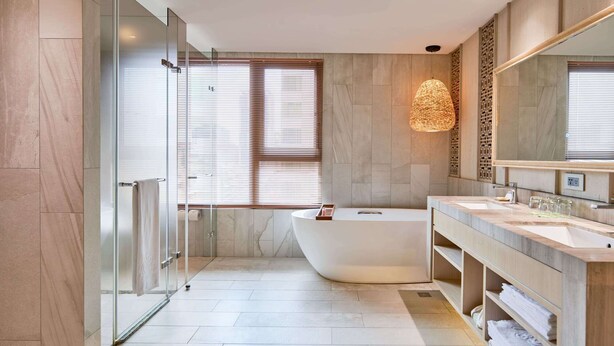 A modern bathroom with a freestanding bathtub, a large mirror, and a vanity with a sink. - arTree hotel (Taipei)