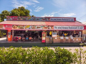 A restaurant with a red roof and a signboard advertising various food items. - The Pink Homes (Ko Pha-ngan)