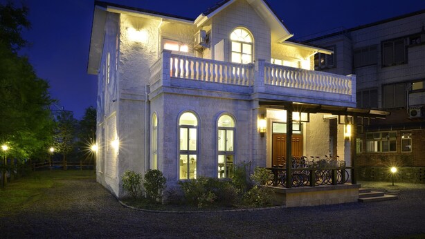 A two-story house with a balcony, large windows, and a well-lit entrance. - Dancing Butterfly Slide Family Inn (Dongshan)