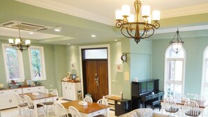 A spacious living room with a dining area, a fireplace, and a television. - Dancing Butterfly Slide Family Inn (Dongshan)
