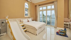 A hotel room with a large bed, a whiteboard, a desk, a chair, a window, and a balcony. - Dancing Butterfly Slide Family Inn (Dongshan)