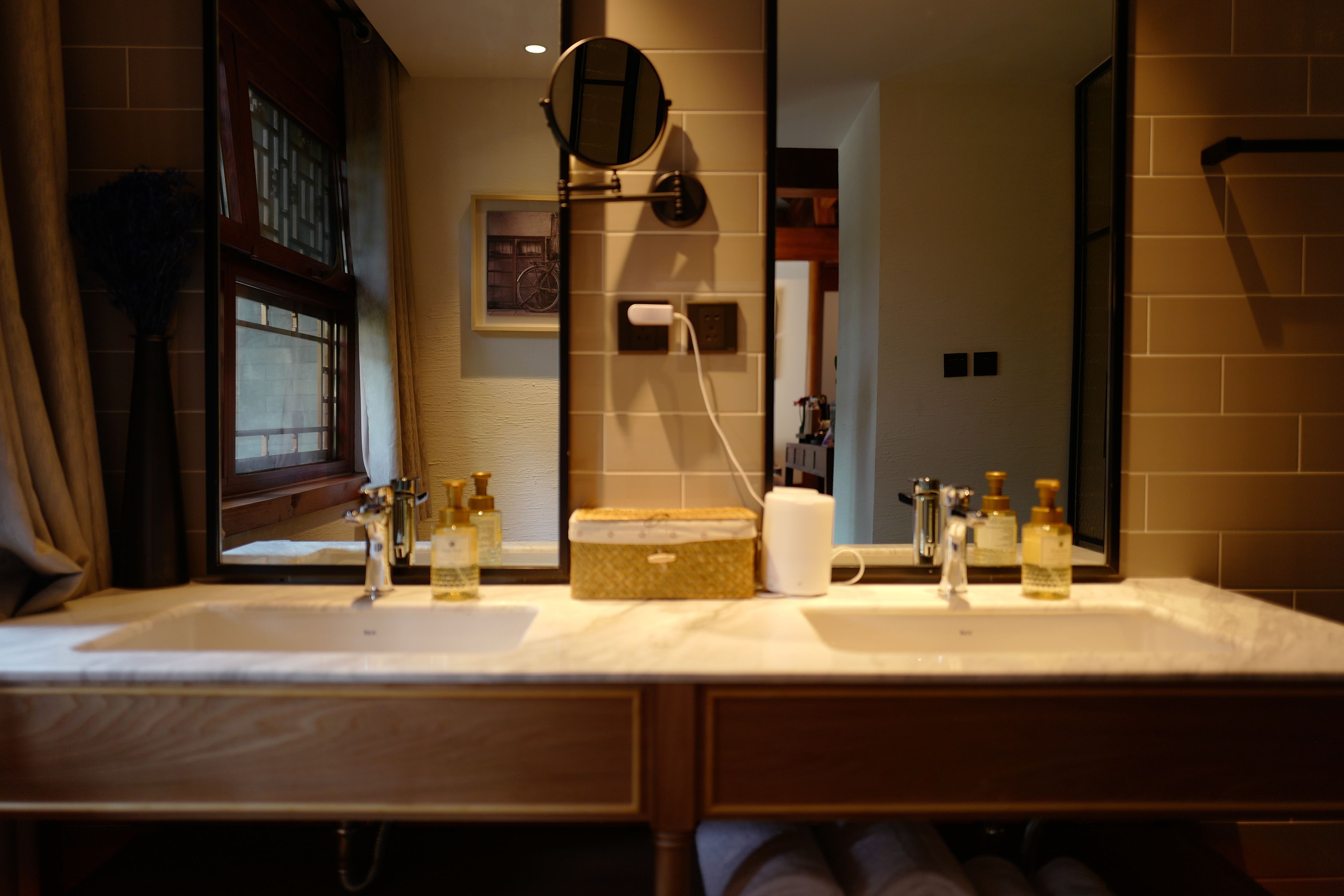 A bathroom with two sinks, a mirror, and toiletries.