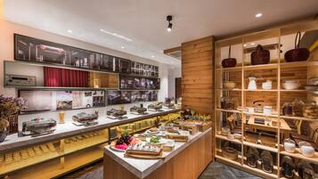 A buffet area with a variety of food items and a display of kitchenware.