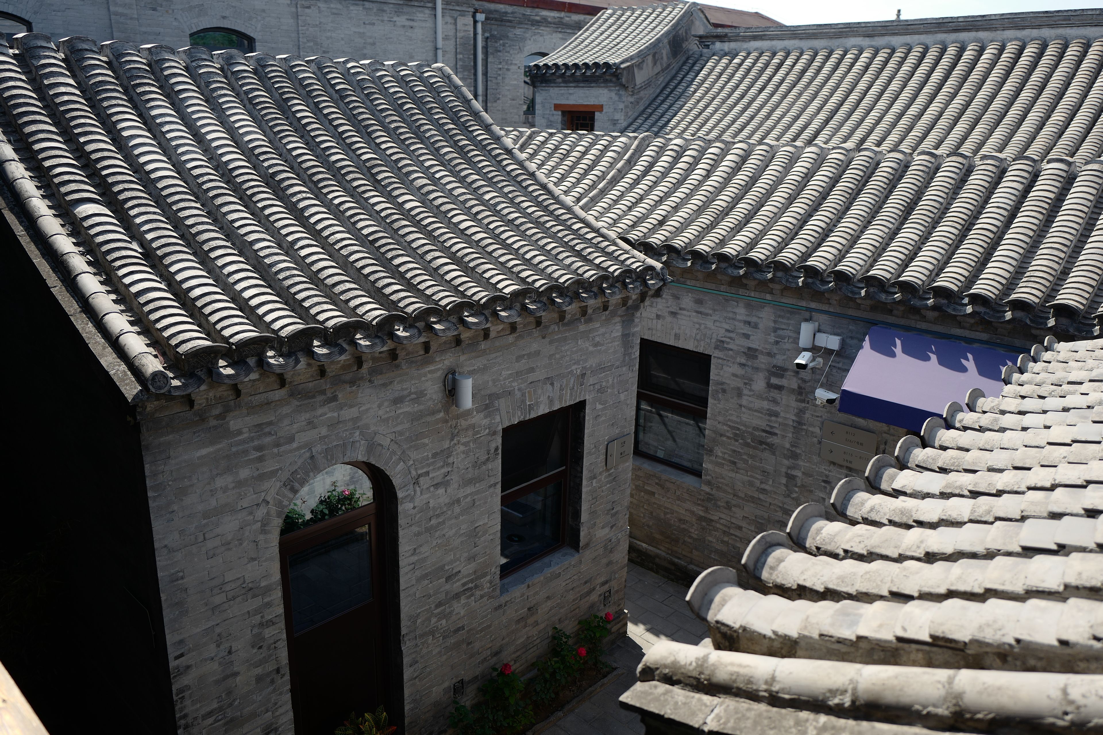 A traditional building with a tiled roof and brick walls, featuring a window and a small door.
