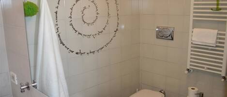 A bathroom with a toilet, bidet, sink, and a towel rack.