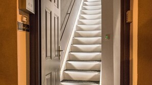 A staircase with a handrail and a door at the top. - La Maison Gustave (Narbonne)