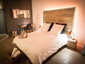 A neatly arranged bedroom with a large bed, a desk, and a chair. - La Maison Gustave (Narbonne)
