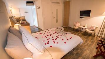 A bedroom with a bed, a TV, a desk, and a chair.