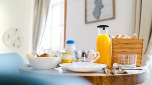 A breakfast table with a bowl, juice pitcher, and bread. - La Maison Gustave (Narbonne)