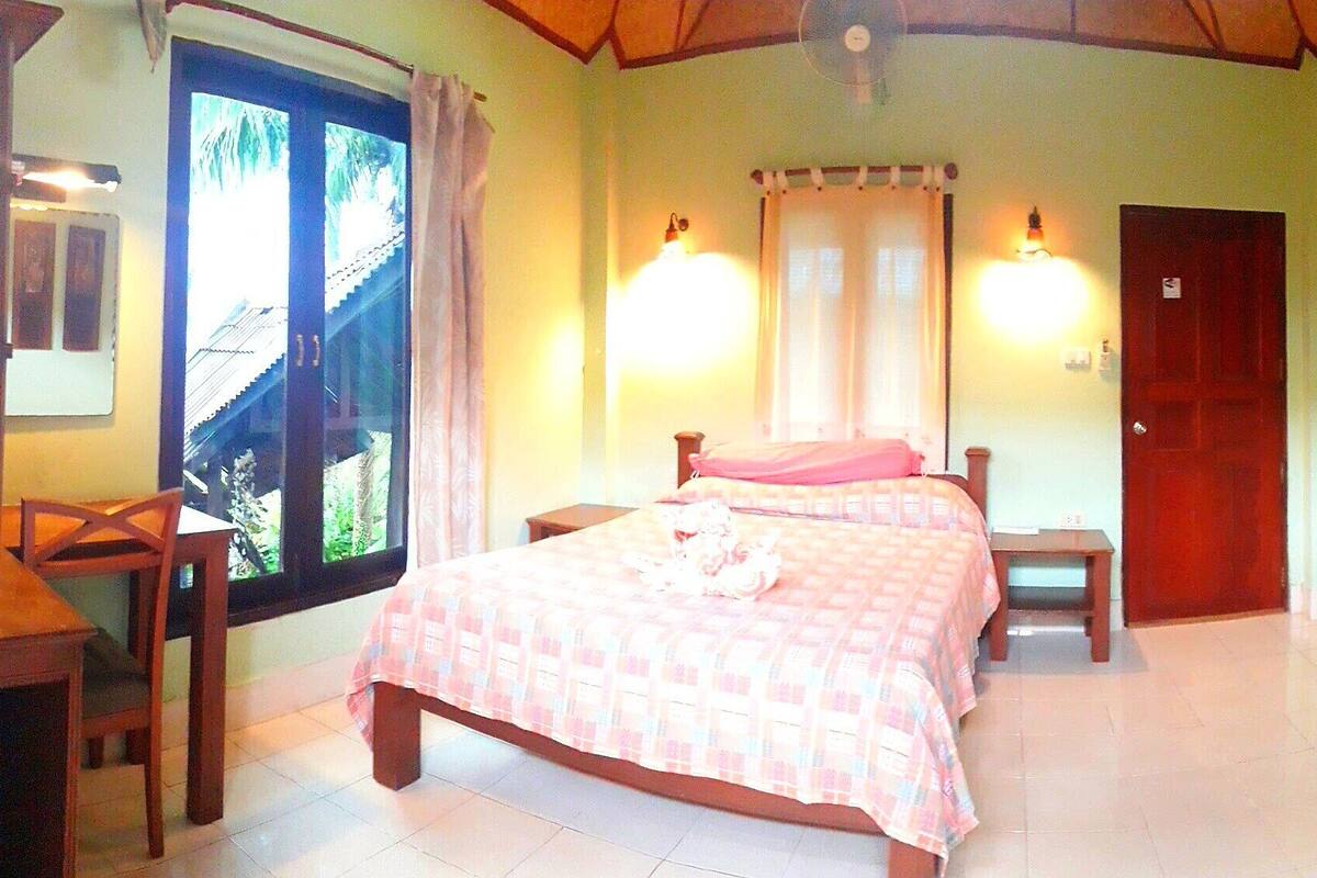 Quarto com cama, mesas de cabeceira, janela e porta.