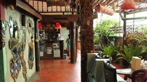 Un intérieur rustique comprenant un comptoir d’accueil, un poste informatique et un mur de briques agrémenté d’éléments décoratifs.