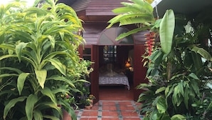 Une pièce confortable avec un lit, une fenêtre et une plante en pot.