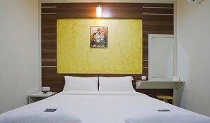 A hotel room with a bed, a nightstand, a bedside table, a mirror, and a wall-mounted artwork. - Golden Night Hotel Sunway (Subang Jaya)