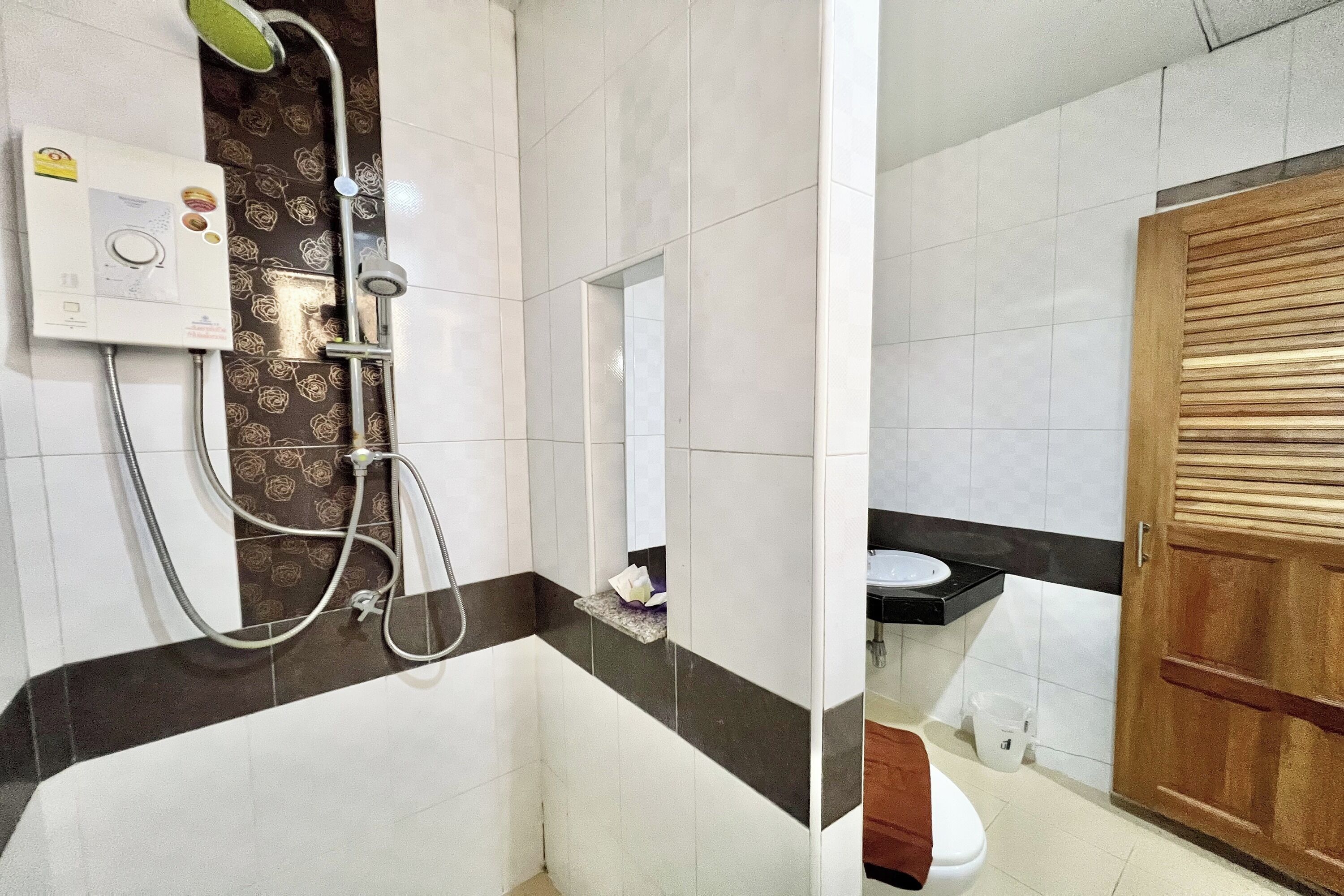 Une salle de bain avec douche, toilettes et lavabo.