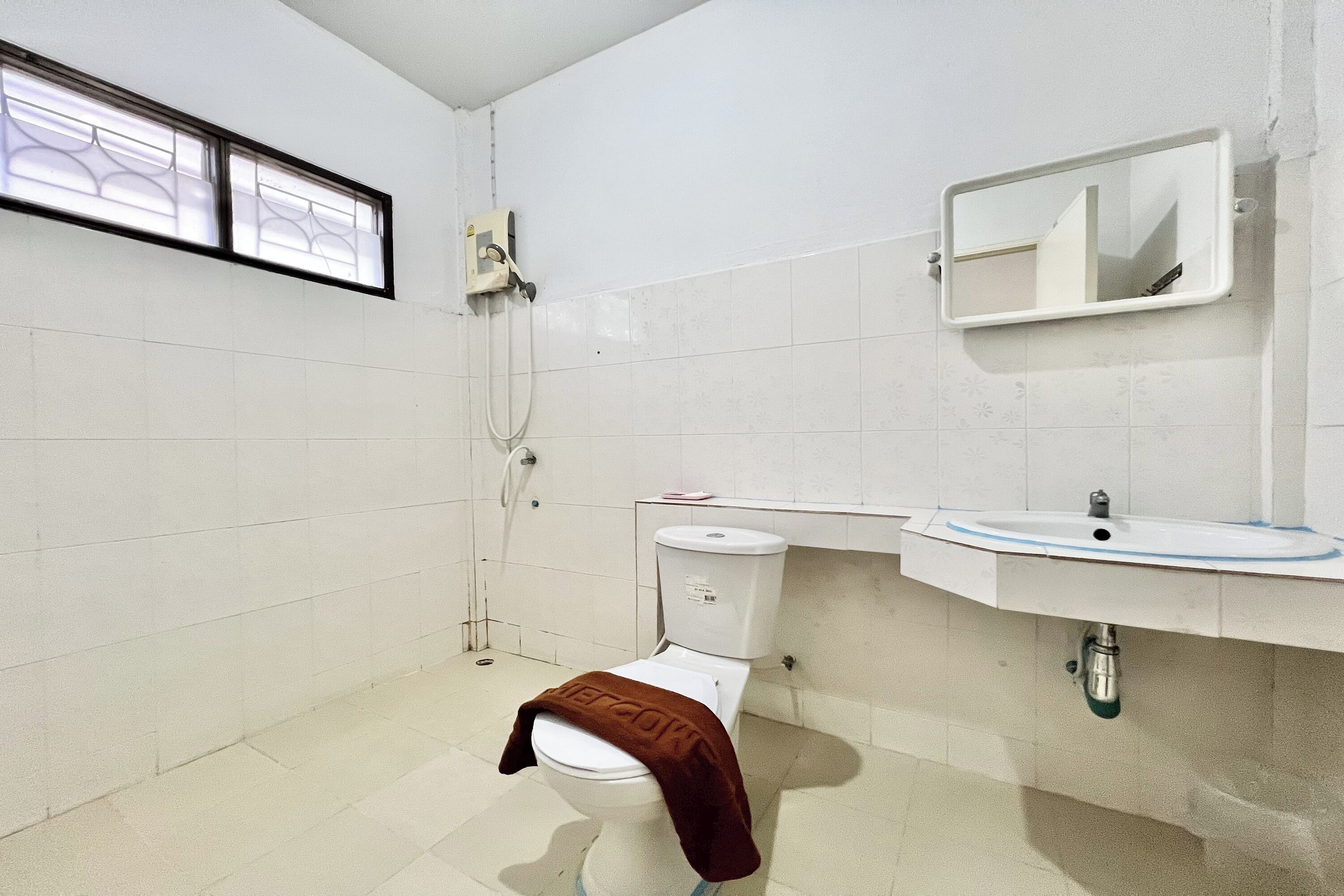 A small, clean bathroom with a toilet, sink, and shower.