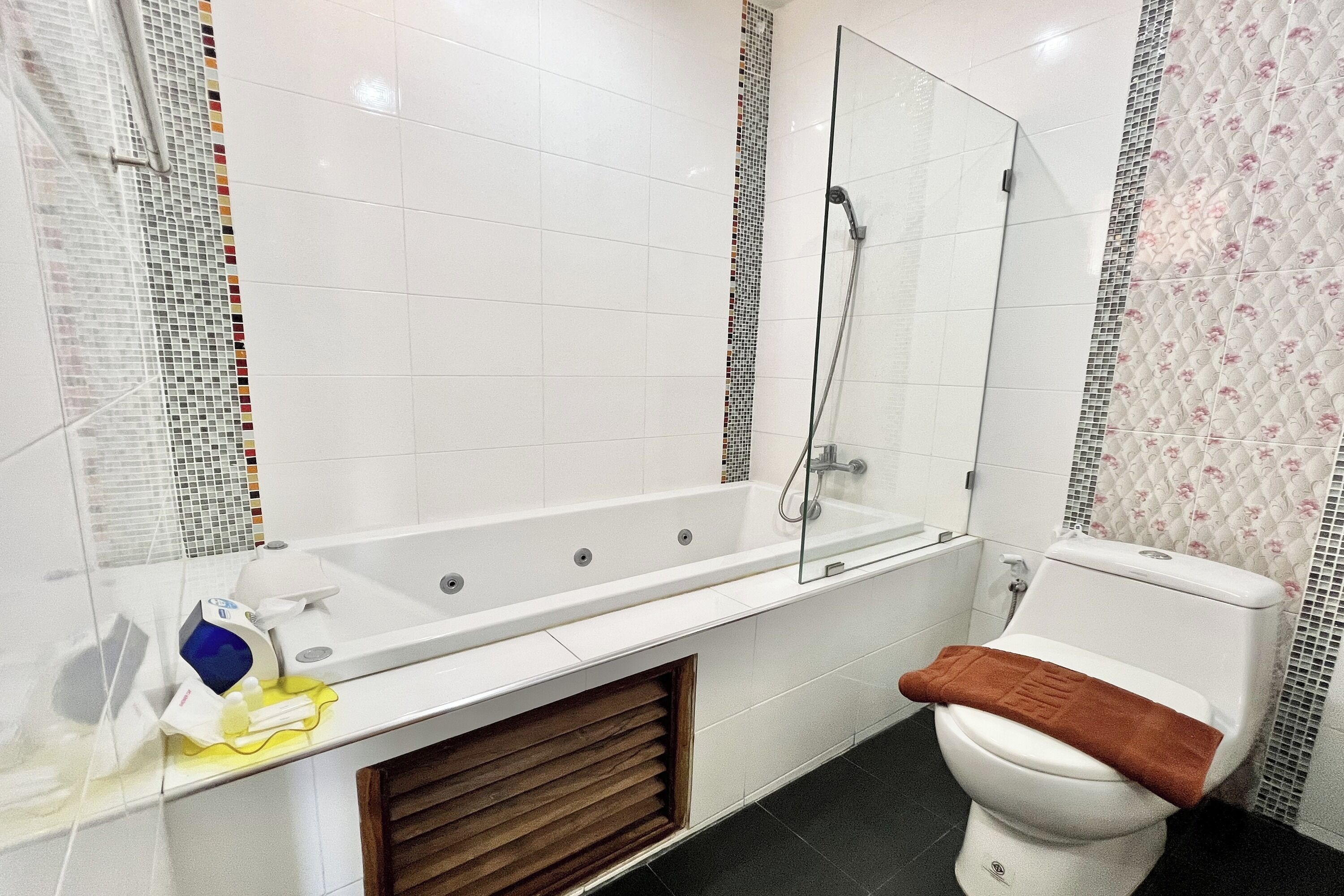 Een badkamer met een witte badkuip, toilet en douche.