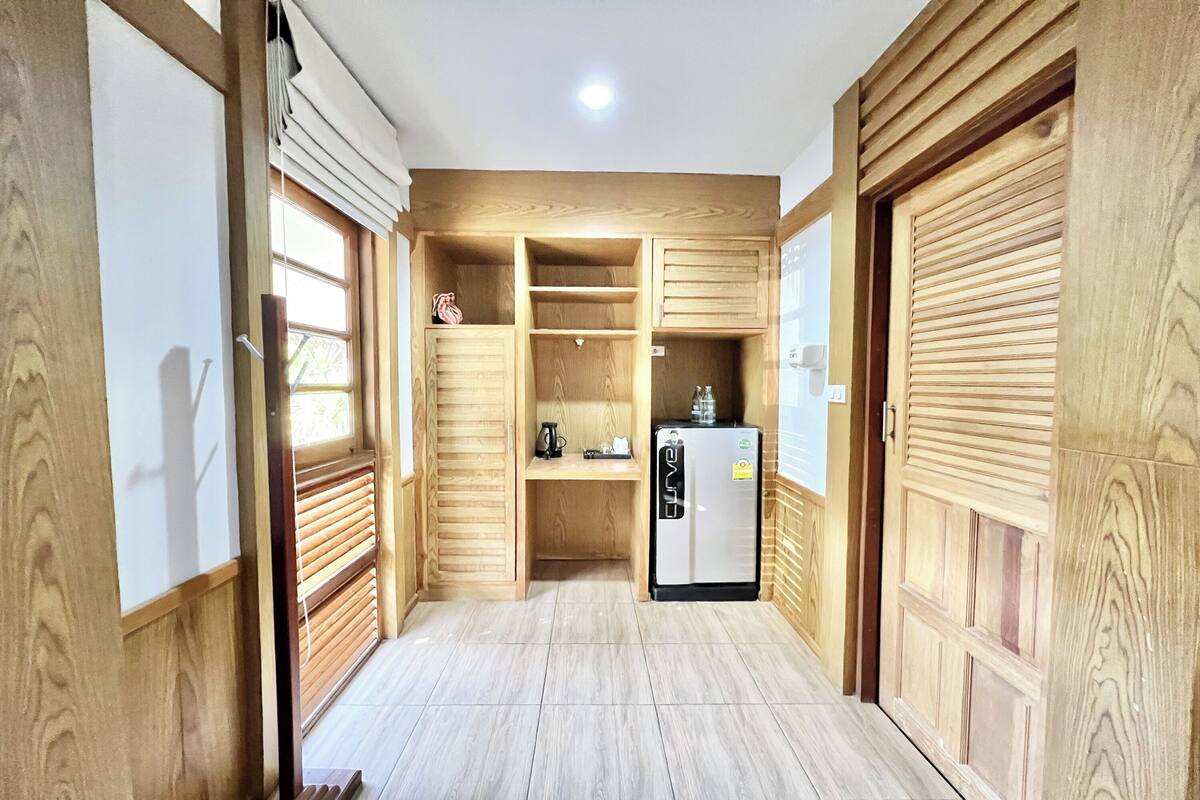 Una cocina compacta con armarios de madera, un refrigerador integrado y una pequeña superficie de encimera.