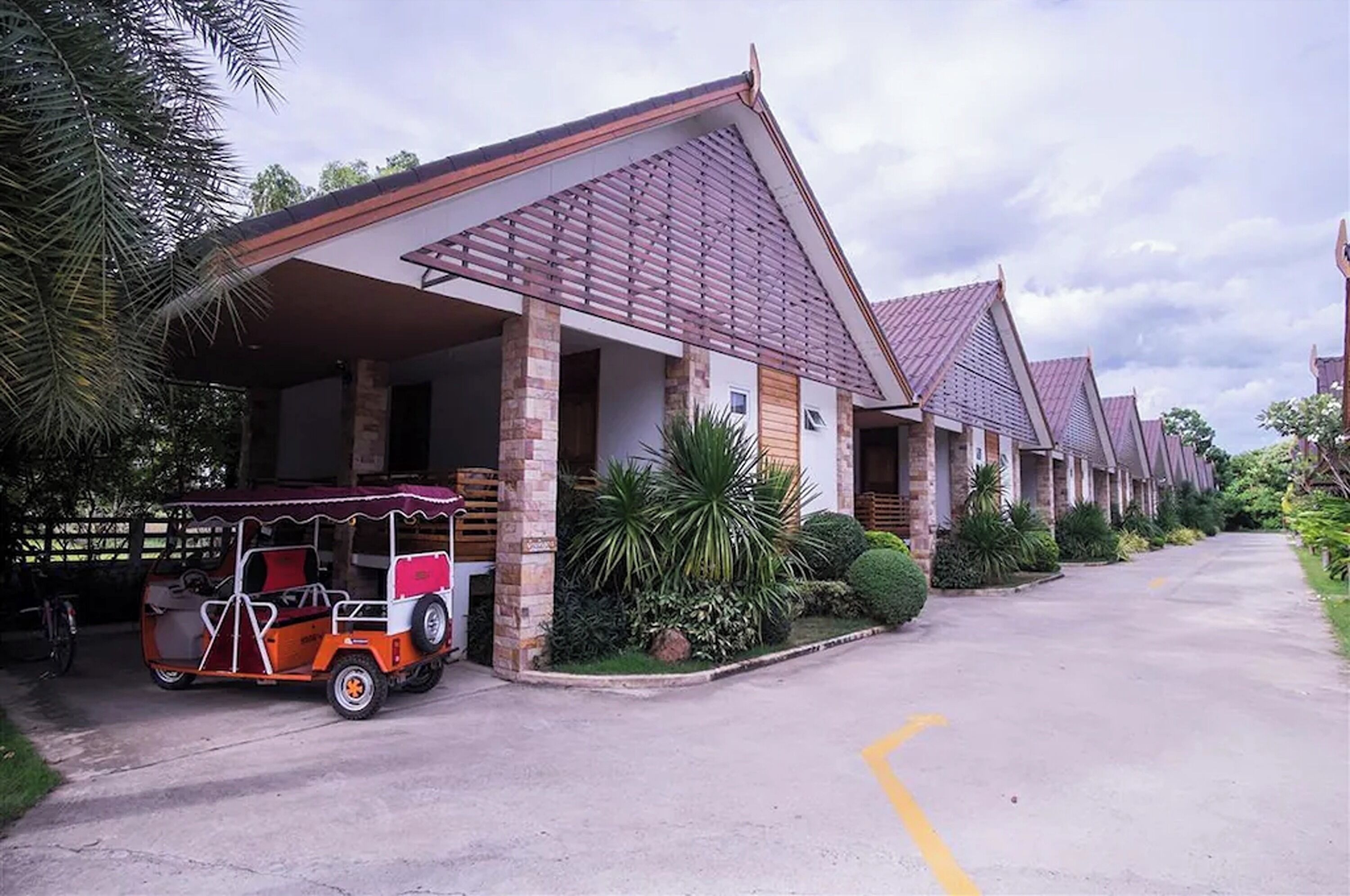 Una hilera de edificios tipo bungalow con un porche cubierto y un carrito de golf estacionado al frente.