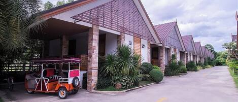 Una hilera de edificios tipo bungalow con un porche cubierto y un carrito de golf estacionado al frente.