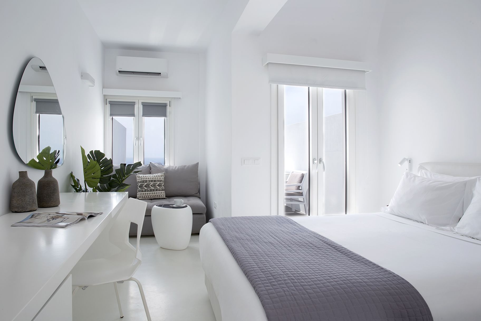 A modern bedroom with a bed, a desk, a chair, and a window.