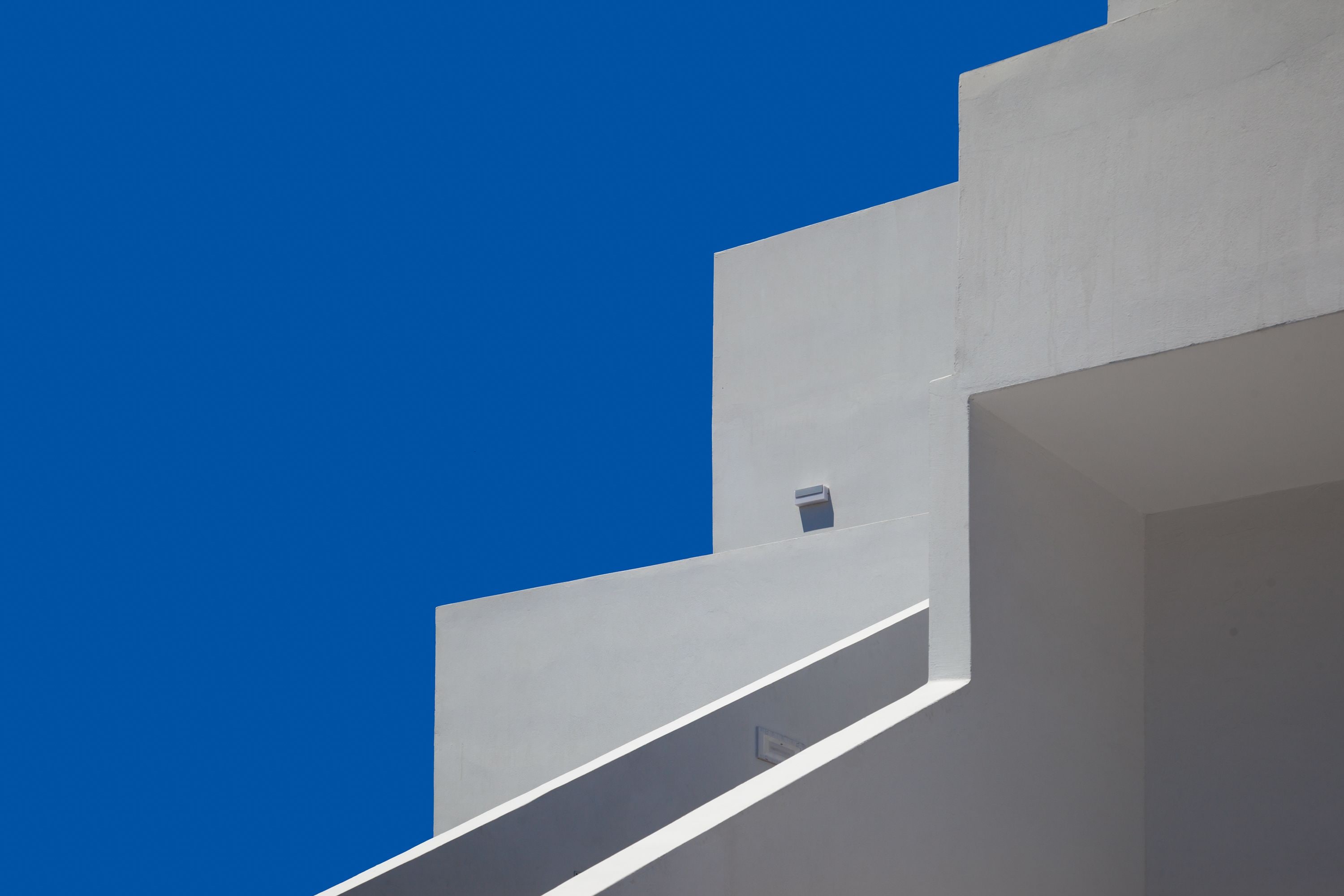 A modern building with a flat roof and a small window.