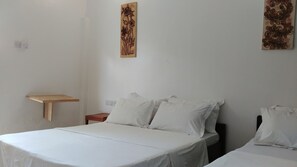 Simple, clean room with a single bed and minimalist decor.