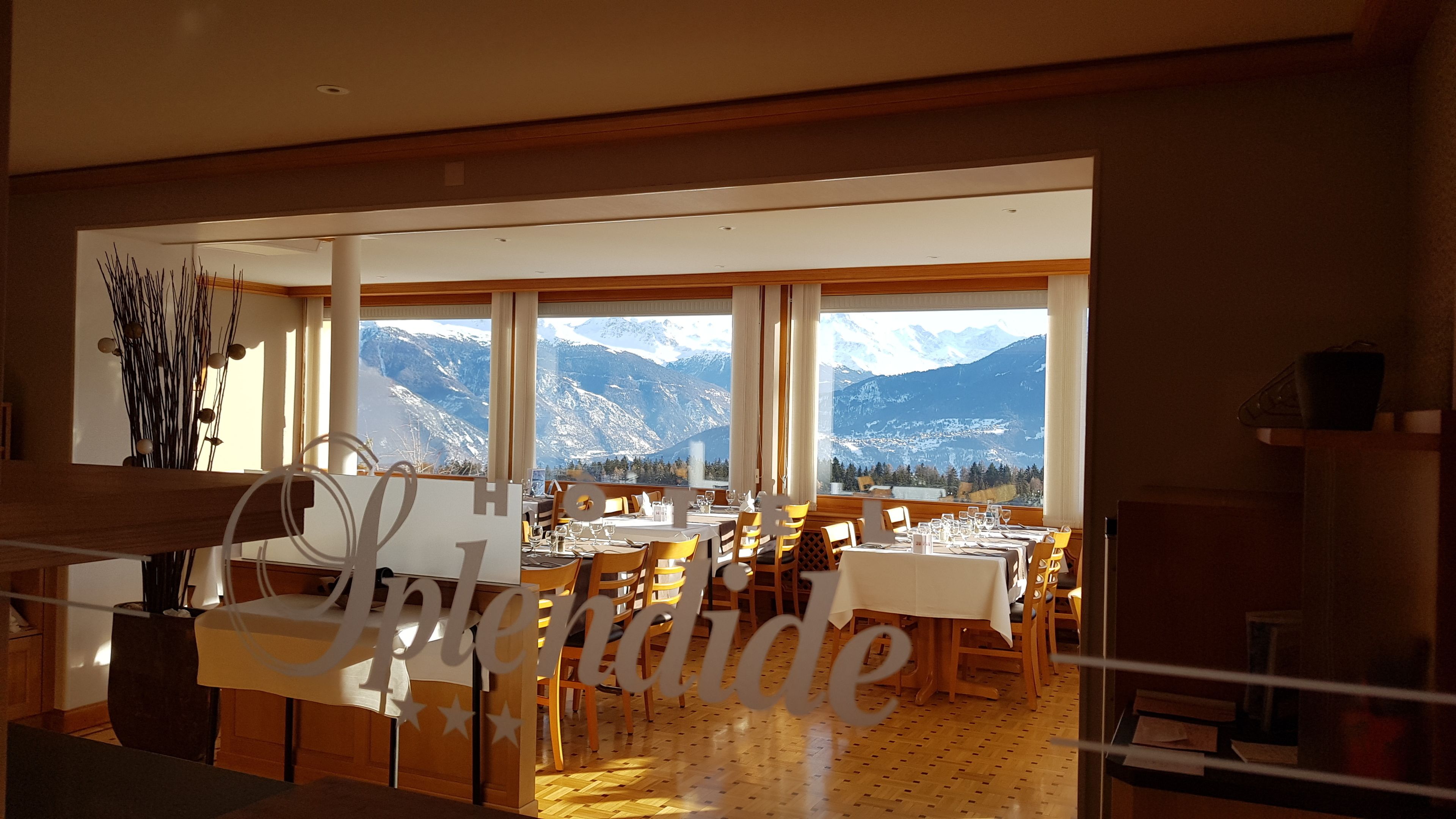 A restaurant with a mountain view, wooden furniture, and a large 'Jupiter' sign.