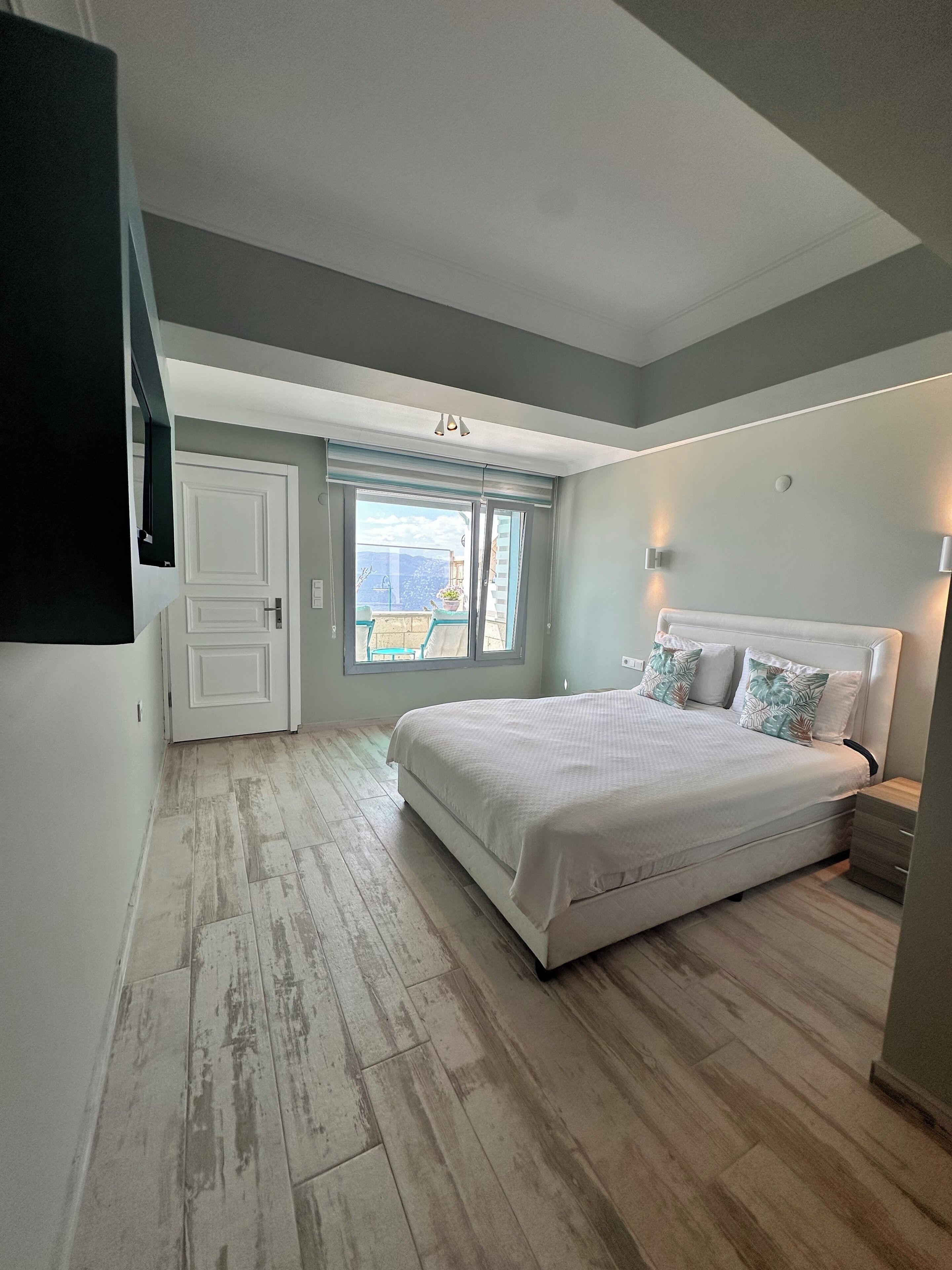 Ein Schlafzimmer mit Bett, Fenster und Tür.