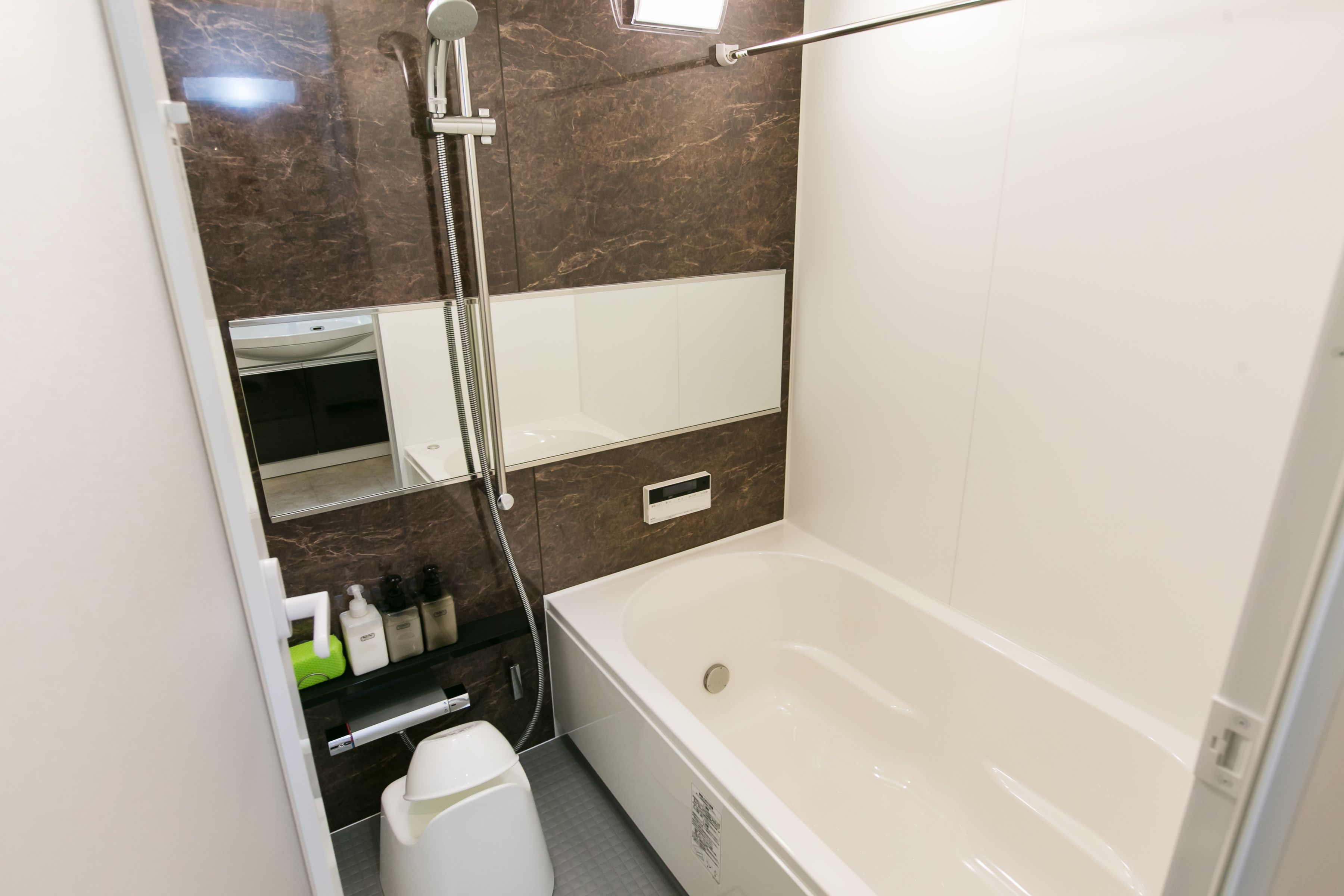 Un baño moderno con bañera, ducha y un espejo grande.