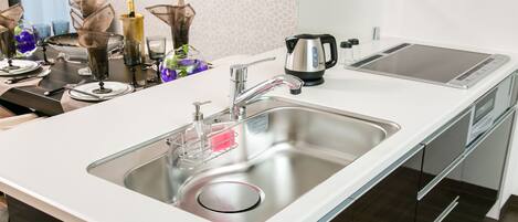 Una cocina moderna con un lavamanos de acero inoxidable, un hervidor y un tostador.