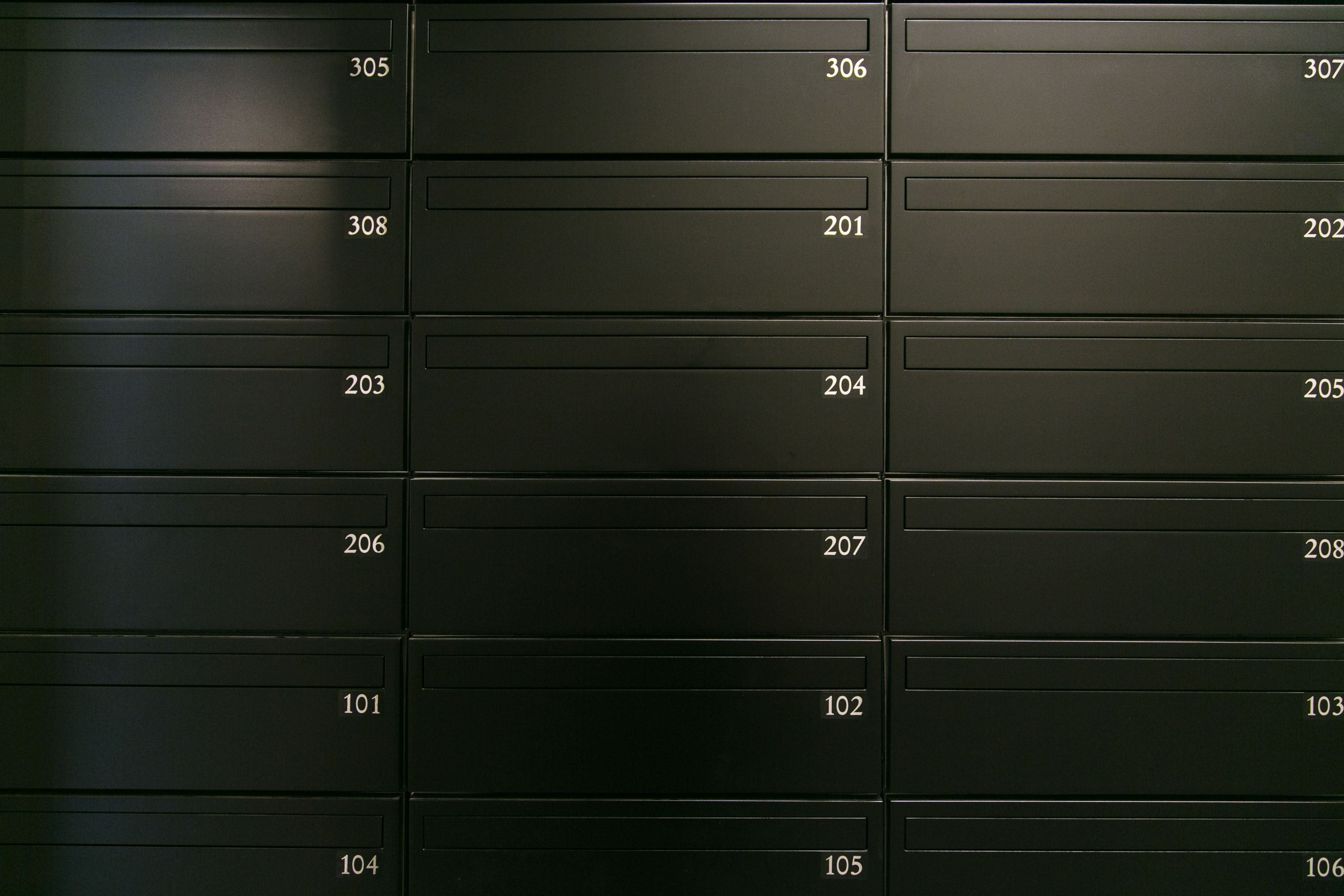 A row of black filing cabinets with numbers on the doors.