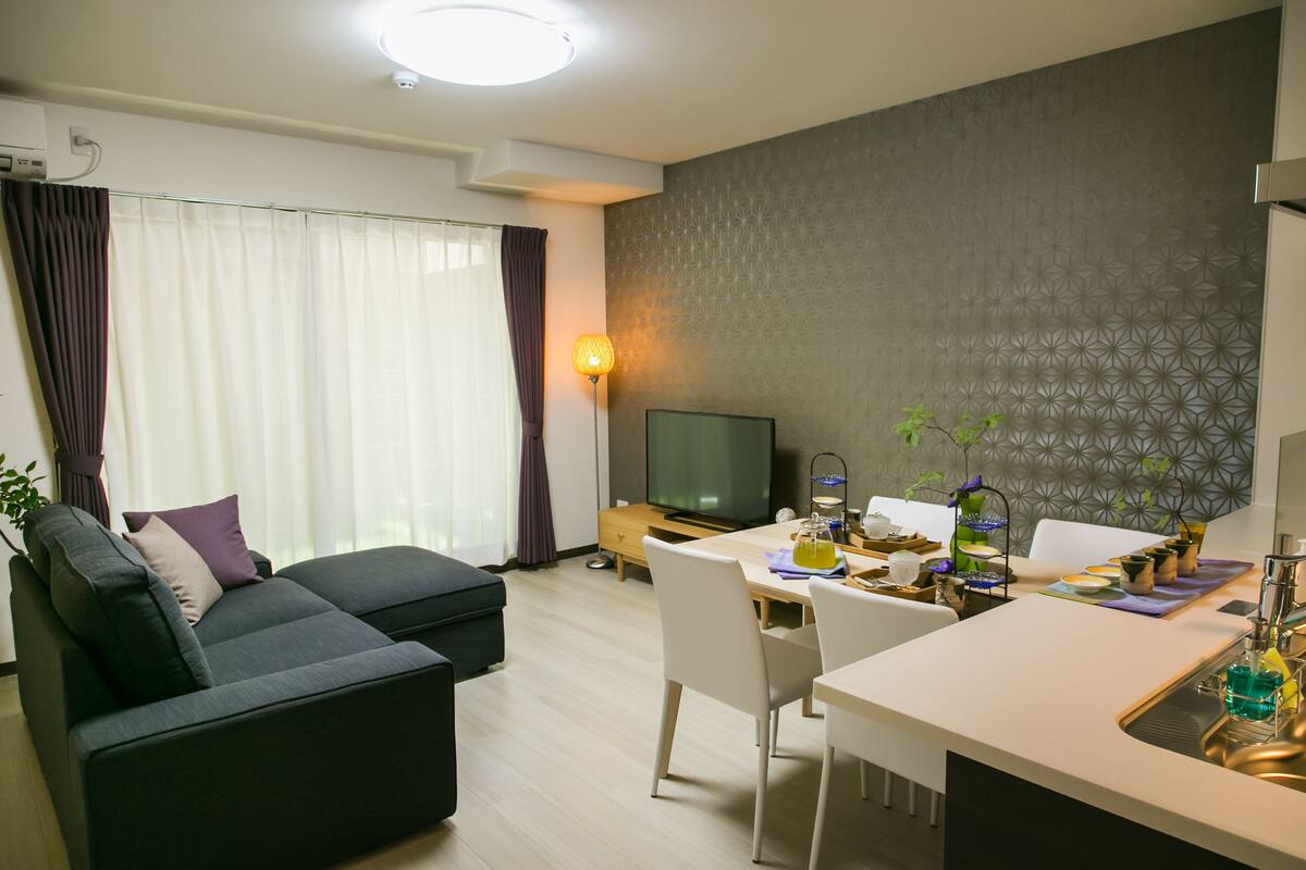 Ein modernes Wohnzimmer mit einer Couch, einem Esstisch und einem Fernseher.