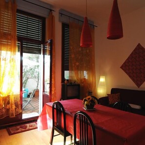 A dining area with a table set for two, a sofa, and a lamp. - B&B Arabesque (Venice)