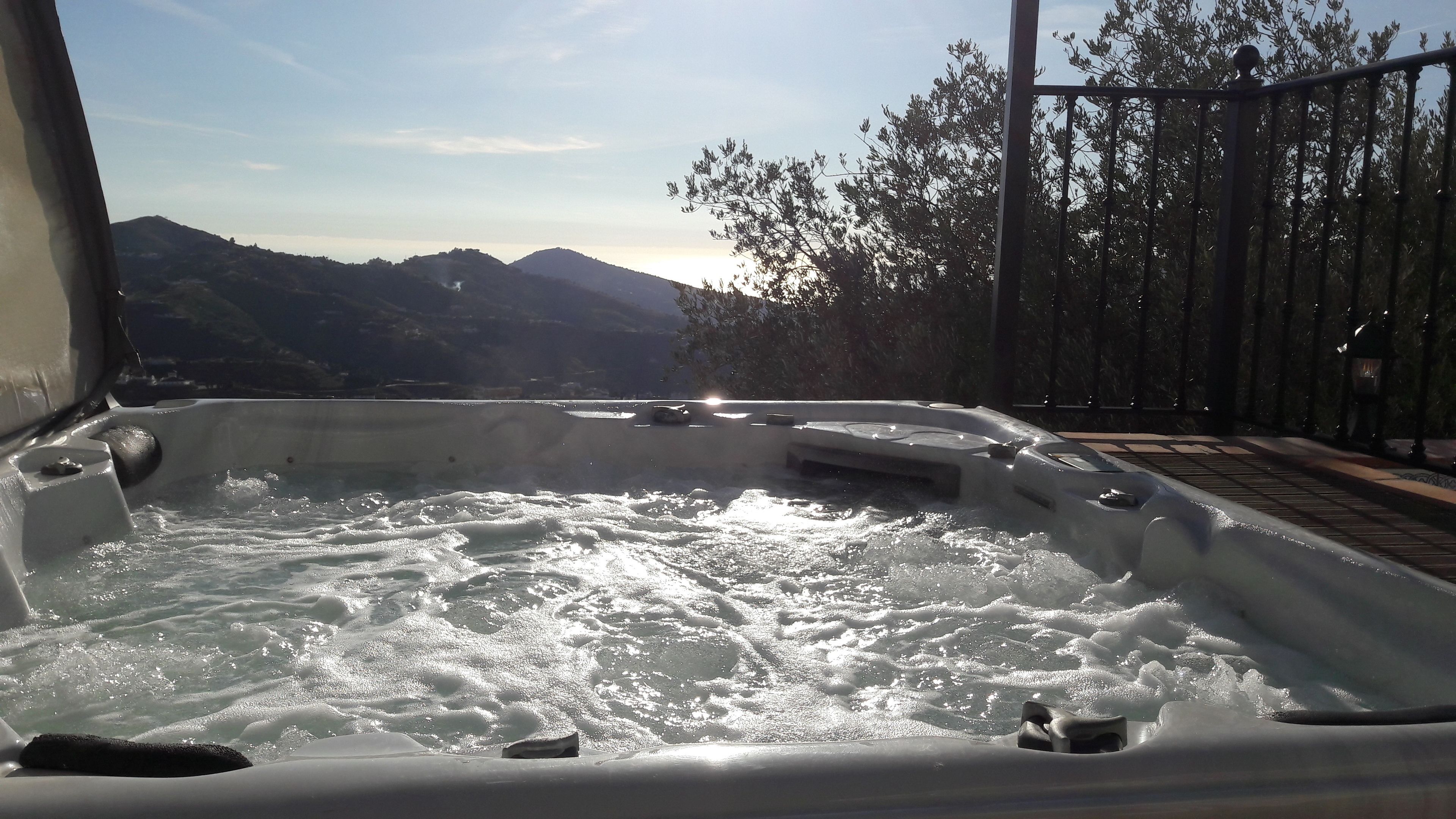 A hot tub with a view of mountains and trees.