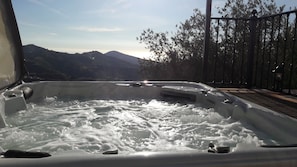 A hot tub with a view of mountains and trees.