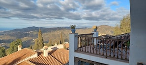 A balcony with a view of a mountainous landscape.