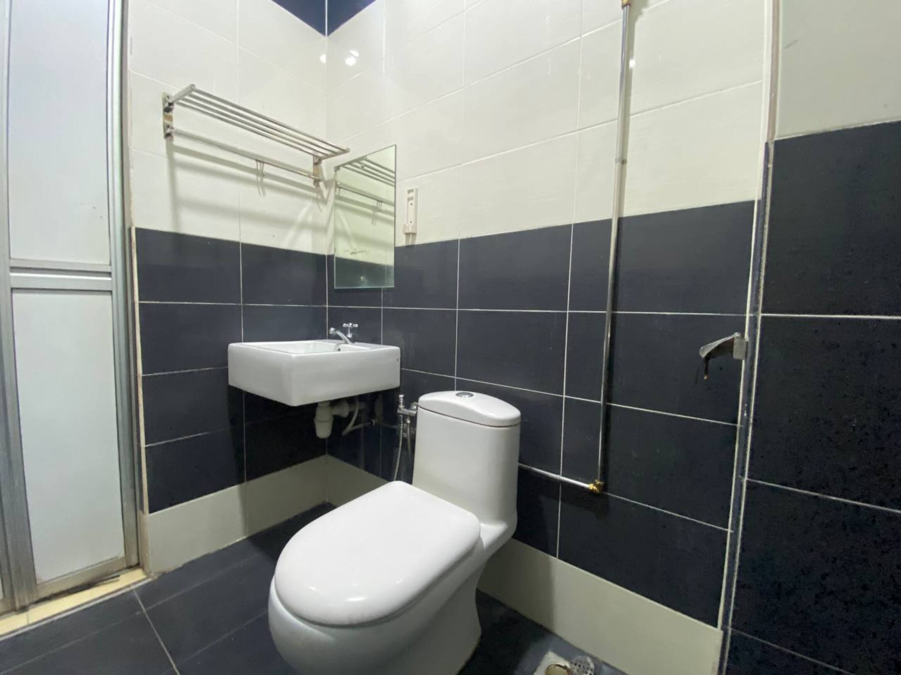 A bathroom with a toilet, sink, and shower.