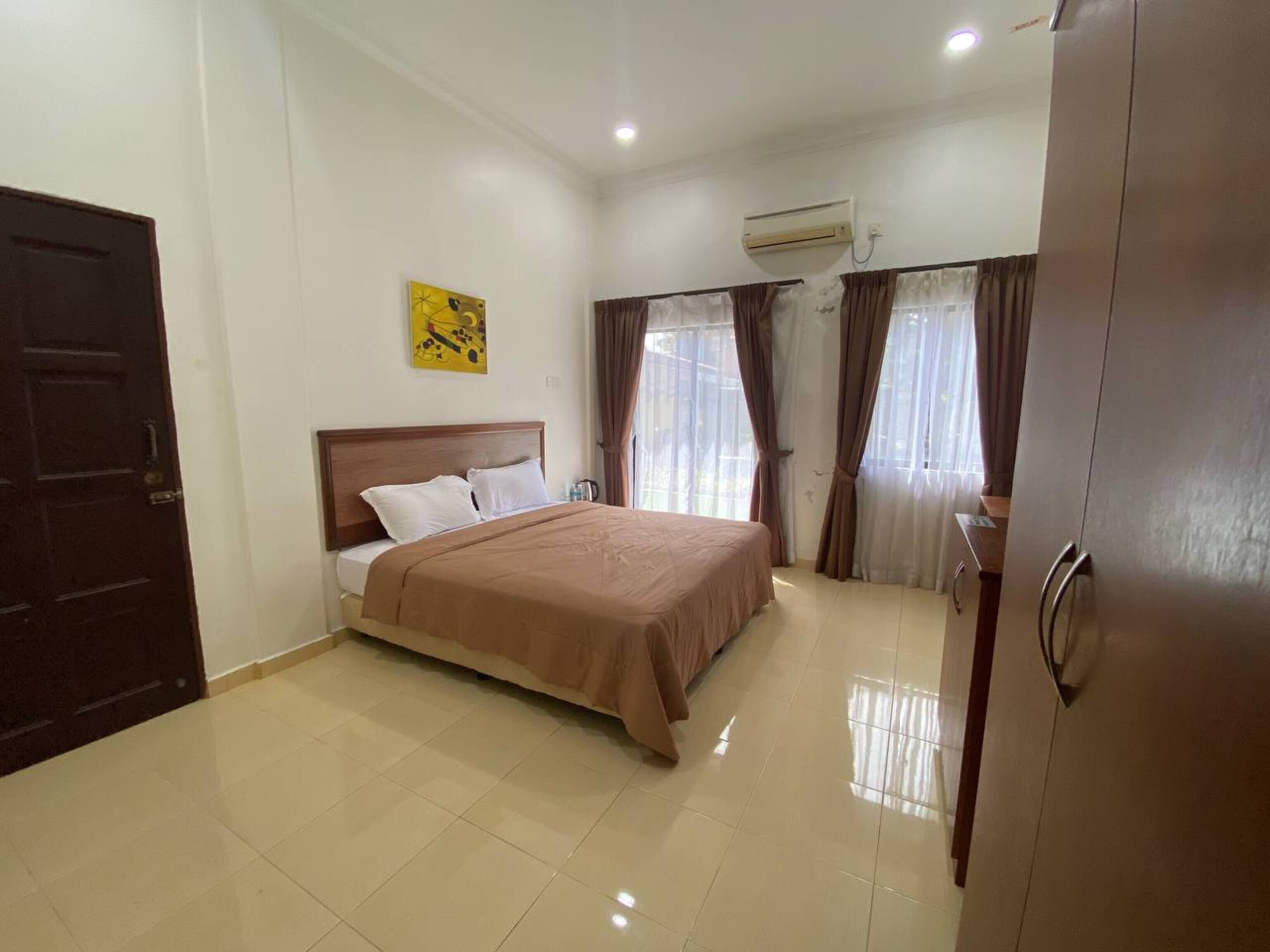 Une chambre d’hôtel équipée d’un lit, d’une armoire, d’un climatiseur et d’une porte.