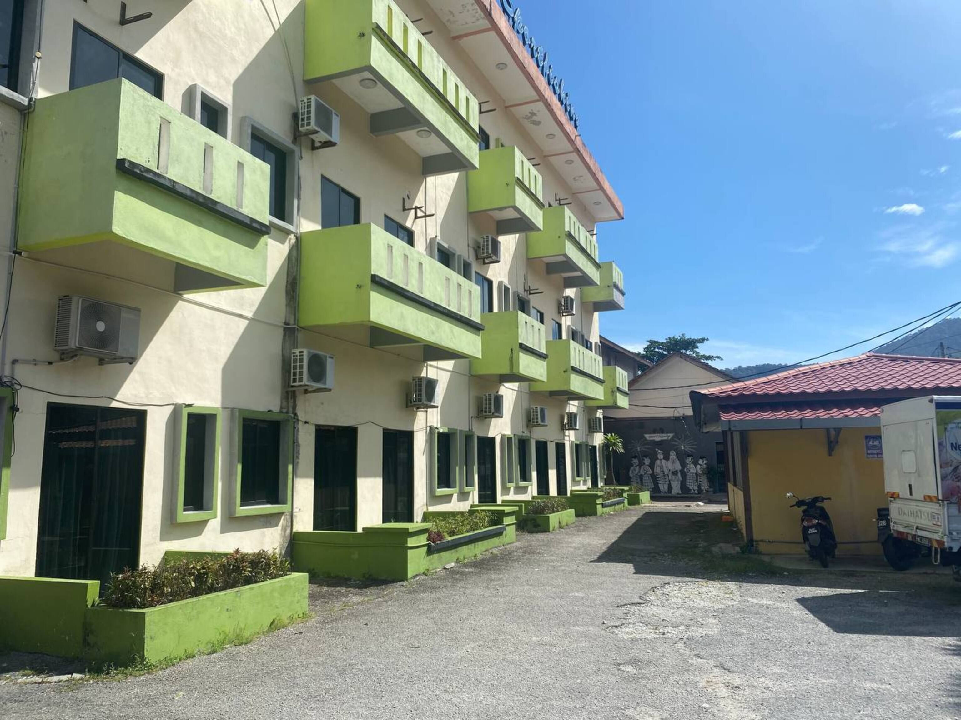 Un immeuble à plusieurs étages doté de balcons verdoyants et de climatiseurs.