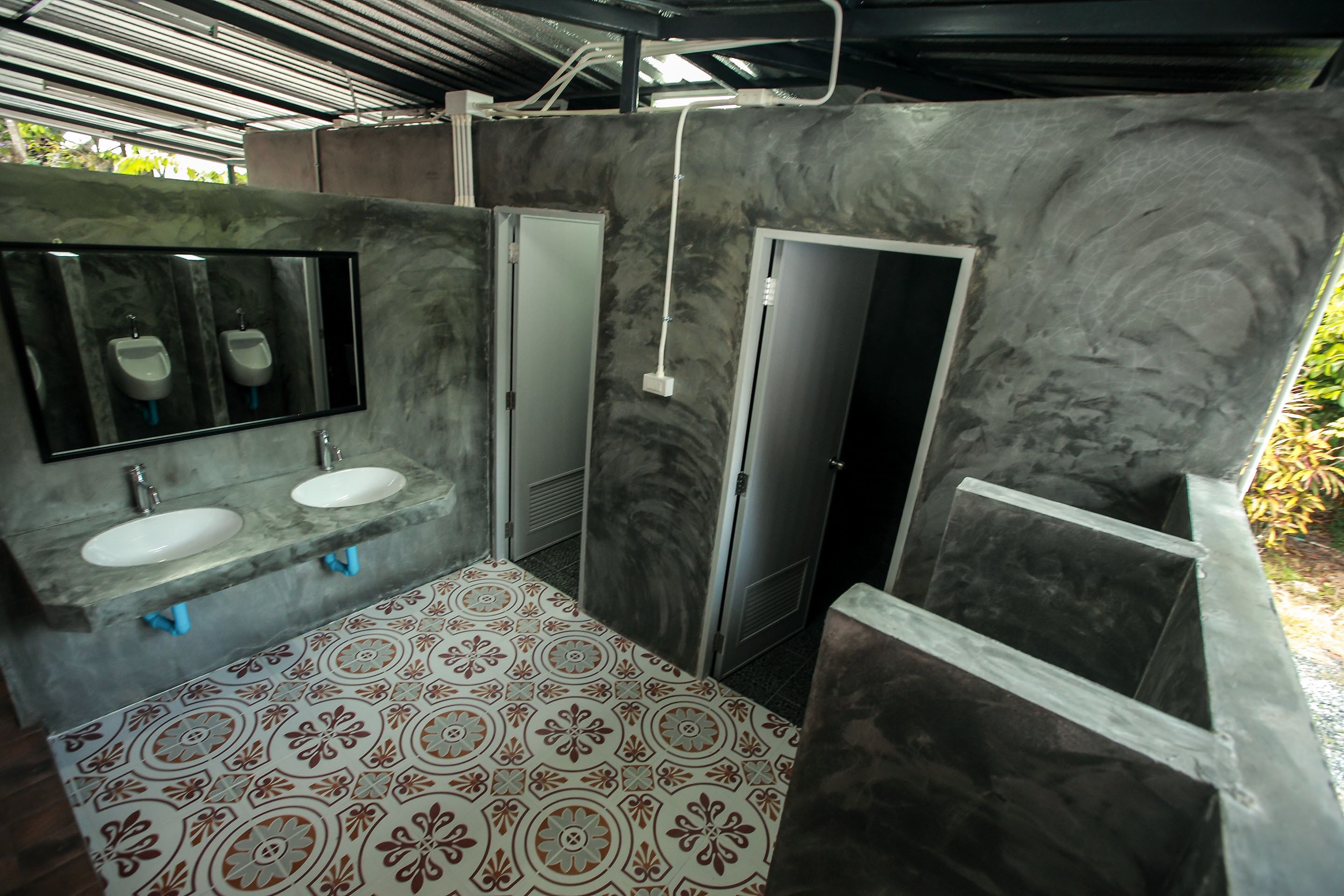 Un baño con dos lavamanos, un espejo y un suelo con diseño.