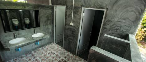 Un baño con dos lavamanos, un espejo y un suelo con diseño.