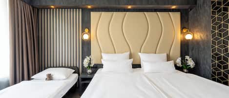 Comfort Triple Room | Minibar, in-room safe, desk, blackout drapes