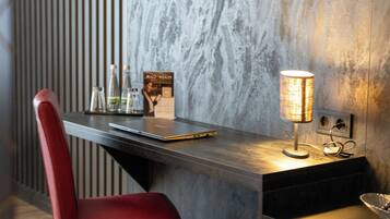 A modern workspace with a laptop, a lamp, and a chair.