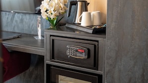 A modern kitchen with a coffee maker, two white mugs, and a digital lock on a cabinet. - PLAZA INN Bruchsal (Bruchsal)